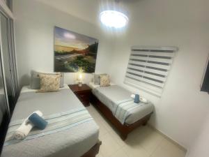 ein Schlafzimmer mit 2 Betten und einem Wandgemälde in der Unterkunft Residencial Maite Vl in Santiago de los Caballeros