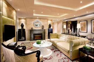 uma sala de estar com um sofá e uma lareira em Kempinski The One Suites Hotel Shanghai Downtown em Xangai