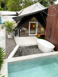 een badkamer met een bad en een wastafel naast een huis bij Anita Camp stay in Khao Sok
