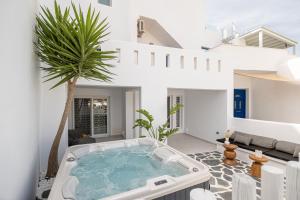 ein weißes Haus mit Whirlpool auf der Terrasse in der Unterkunft Almiriki Naxos Beachside Living in Plaka