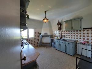 a kitchen with blue cabinets and a clock on the wall at Casa Azul Vales in Penalva do Castelo +15 photos