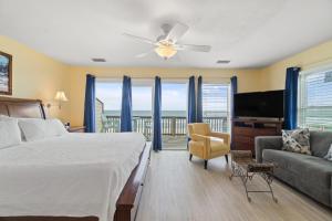 una camera da letto con un letto, un divano e una televisione di Labacoco West a Gulf Shores