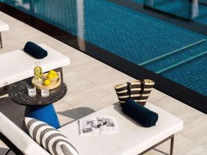 a table and chairs next to a swimming pool at TRIBE Living Bangkok Sukhumvit 39 in Bangkok