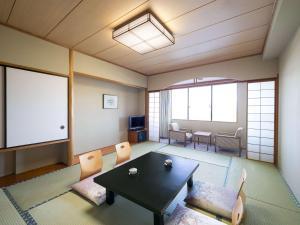 那須町にあるグランドメルキュール那須高原リゾート＆スパのテーブルと椅子、スクリーンが備わる客室です。