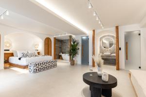 biała sypialnia z łóżkiem i stołem w obiekcie Almiriki Naxos Beachside Living w mieście Plaka