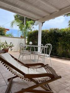 a patio with a table and chairs on a patio at Villetta Mara. A due passi da Gallipoli. in Marina di Mancaversa