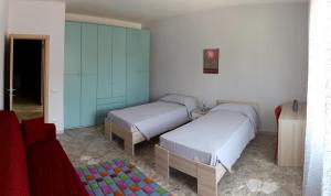 1 Schlafzimmer mit 2 Betten und einem Sofa in der Unterkunft Casa Vacanze La Perla in Matera