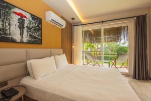 a bedroom with a bed and a window with a view at Morina Deluxe Hotel in Oludeniz