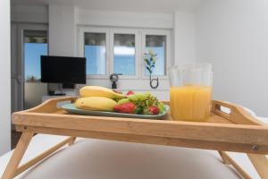 a tray with a plate of fruit and a glass of orange juice at Makaria in Split +10 photos