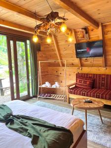 a bedroom in a log cabin with a bed and a couch at Yaşam Bungalows Otel in Çamlıhemşin