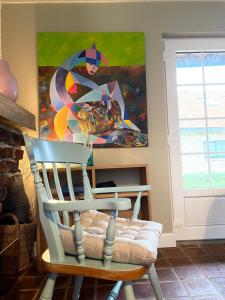 una sedia in una stanza con un dipinto sul muro di Les Cottages d'Orient Premium a Mesnil-Saint-Père