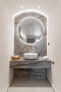 uma casa de banho com um lavatório e um espelho em Nikos & Maria Apts - Suites em Plaka