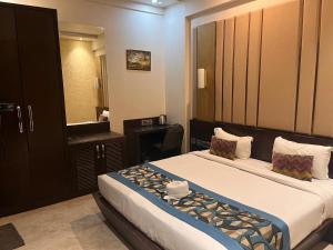 - une chambre d'hôtel avec un lit et un miroir dans l'établissement HOTEL JODHA THE GREAT, à Agra