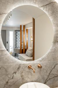 espejo de baño con lavabo y sala de estar. en Nikos & Maria Apts - Suites, en Plaka