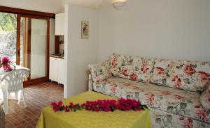 sala de estar con sofá y mesa con flores. en Tenuta Molino di Mare, en Rodi Garganico