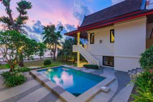 a villa with a swimming pool in front of a house at Koh Chang Grandview Resort in Ko Chang