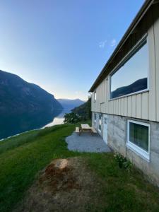 a building with a picnic table next to a lake at Aurland Feriehus in Aurland