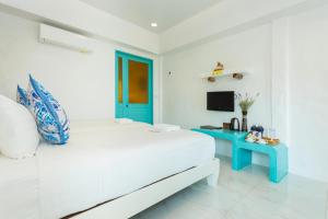 a white room with a bed and a blue table at Koh Chang Grandview Resort in Ko Chang