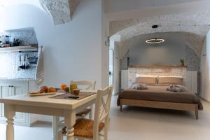 a bedroom with a bed and a table and a table and a tableablish at La Chianca, Farinella - Suits & Apartments in Putignano