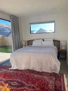 a bedroom with a large bed with a large window at Remarkable stay in Queenstown in Frankton Wharf