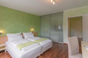 um quarto com uma cama branca e uma parede verde em Waldhotel Brand's Busch em Bielefeld