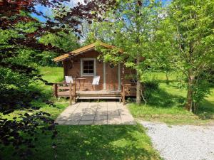 Cabaña de madera pequeña con 2 sillas en el patio en Polgwedhen Lodge en Truro