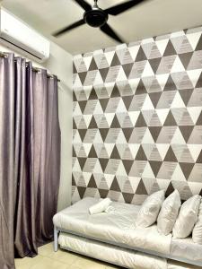 um quarto com uma cama com uma parede geométrica em The Amore Homestay Klebang, Melaka em Malaca
