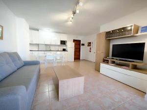 ein Wohnzimmer mit einem Sofa und einem großen TV in der Unterkunft Arenitas Sunset Apartment 1 in Santa Cruz de Tenerife
