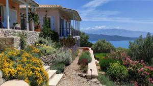 a garden in front of a house with flowers at Die Drei Grazien, luxuriöse Villa mit eigenem Pool in Katouna