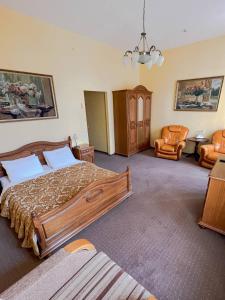 um quarto com uma cama grande e uma cadeira em Wien Hotel em Lviv