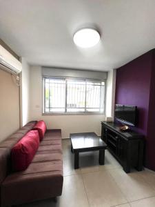 a living room with a couch and a flat screen tv at Apartments4you Maria in Bat Yam