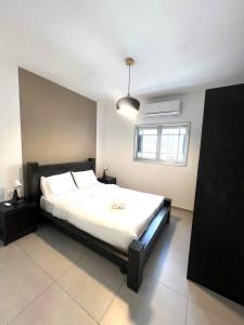 a bedroom with a large white bed with a window at Apartments4you Maria in Bat Yam
