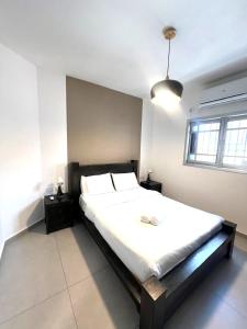 a bedroom with a large bed with white sheets at Apartments4you Maria in Bat Yam