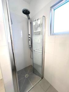 a shower with a glass door in a bathroom at Apartments4you Maria in Bat Yam