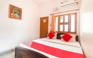 a bedroom with a bed with red pillows on it at Kesher Paying Guest House in Varanasi