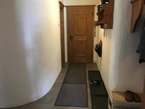 a hallway with a door and a floor with a rug at 3 12 Zimmer Wohnung "Haus Fless" in Klosters