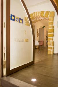 Cette chambre dispose d'un grand réfrigérateur blanc et d'un mur en briques. dans l'établissement La Casa di Ninì, à Agrigente