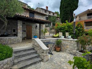 een stenen huis met een stenen muur en een trap bij Kuća za odmor Ameli in Mošćenička Draga