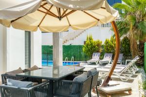 a patio with a table and an umbrella at Luxury villa Ada Marin in Kusadası
