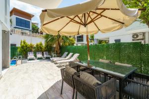 a patio with a table and an umbrella at Luxury villa Ada Marin in Kusadası