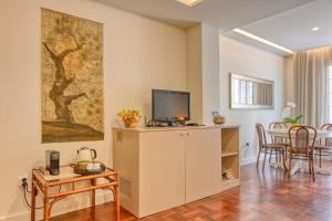a living room with a tv on a cabinet at Colombo Square, a Home in Madeira in Funchal