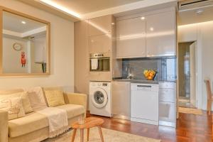 a living room with a couch and a kitchen at Colombo Square, a Home in Madeira in Funchal