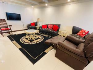 a living room with two couches and a tv at Misty Mountain in Murree