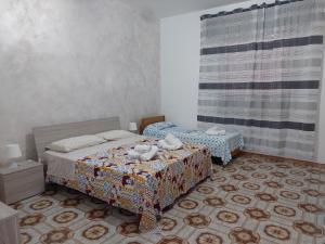 1 Schlafzimmer mit 2 Einzelbetten und einem Vorhang in der Unterkunft Casa Rizza in Portopalo