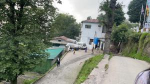 a group of people walking down a dirt road at Misty Mountain in Murree