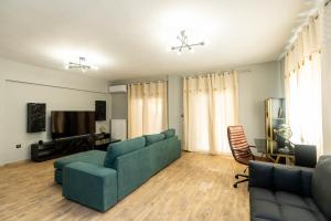 a living room with a couch and a television at Heated Pool Villa in Thessaloniki - Urban Oasis in Thessaloniki