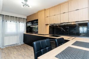 a kitchen with wooden cabinets and a table and chairs at Heated Pool Villa in Thessaloniki - Urban Oasis in Thessaloniki +15 photos