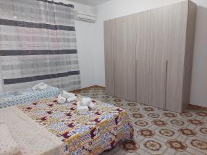 Schlafzimmer mit einem Bett und einem Holzschrank in der Unterkunft Casa Rizza in Portopalo