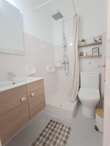 uma casa de banho com um WC, um lavatório e um chuveiro em Philippos Apartments em Acharavi