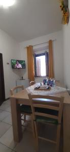 ein Esszimmer mit einem Holztisch und einem Fenster in der Unterkunft Pan di Zucchero in Iglesias